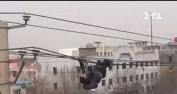 Пьяный китаец взобрался на электрический столб и лег на провода