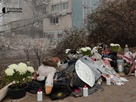 У Тернополі люди несуть квіти та іграшки до будинку, зруйнованого російською ракетою